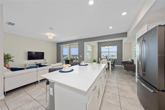 kitchen featuring a kitchen island, light tile patterned floors, white cabinets, and stainless steel fridge with ice dispenser