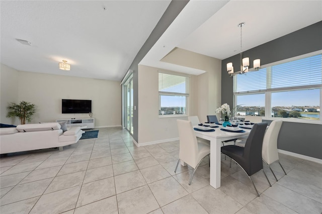 dining area with light tile patterned flooring and a chandelier