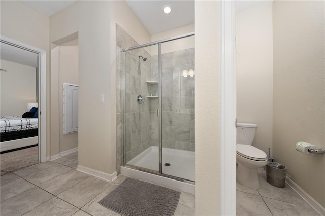 bathroom with tile patterned floors, toilet, and a shower with shower door