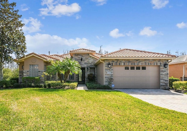 mediterranean / spanish home featuring a garage and a front lawn