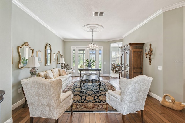 living room featuring crown molding, dark hardwood / wood-style flooring, and an inviting chandelier