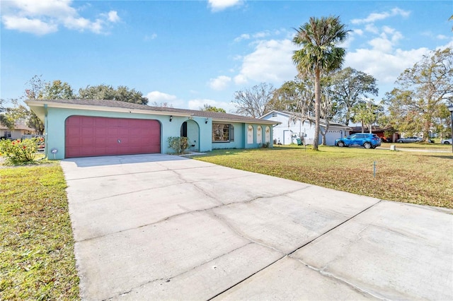 ranch-style house featuring a garage and a front lawn