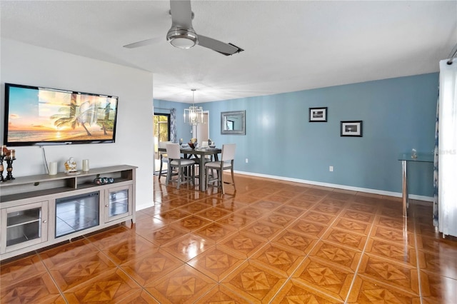 dining space with tile patterned flooring and ceiling fan with notable chandelier