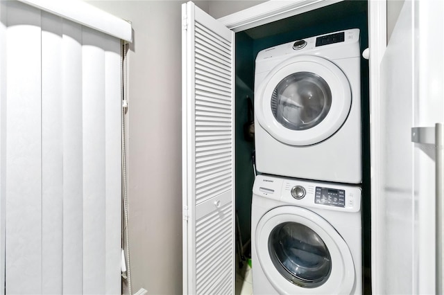 washroom featuring stacked washer / drying machine