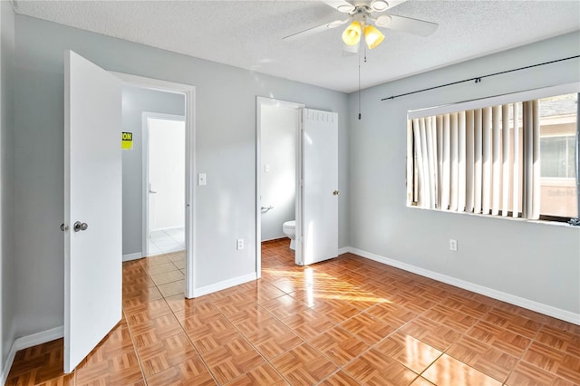 unfurnished bedroom featuring light parquet flooring, connected bathroom, ceiling fan, and a textured ceiling