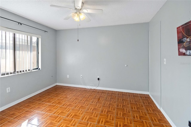 unfurnished room featuring ceiling fan, light parquet flooring, and a textured ceiling