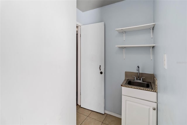 clothes washing area with sink and light tile patterned floors