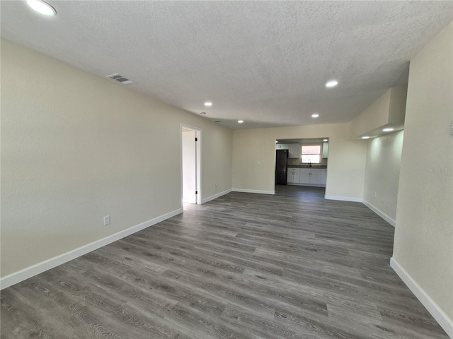 unfurnished living room with dark hardwood / wood-style floors and a textured ceiling