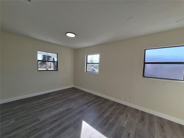 empty room with dark hardwood / wood-style flooring