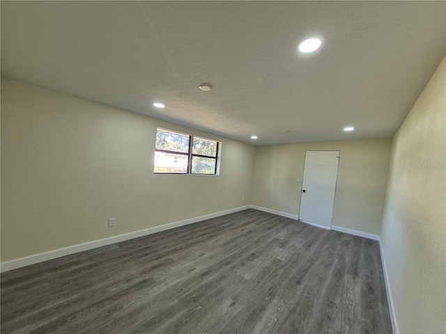 empty room featuring dark wood-type flooring and a textured ceiling