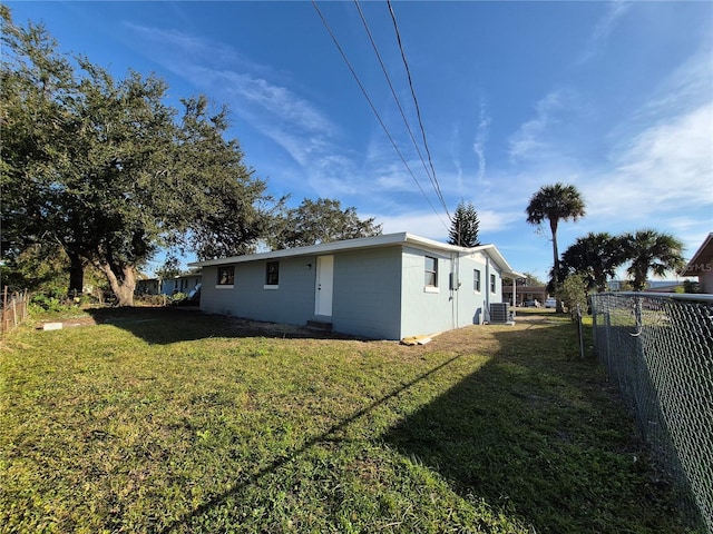 exterior space with central AC unit and a yard