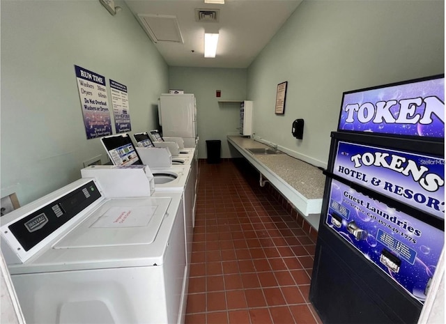 laundry room featuring washer and clothes dryer and dark tile patterned floors