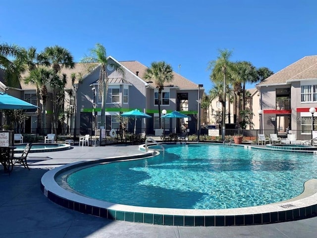 view of swimming pool featuring a community hot tub and a patio area