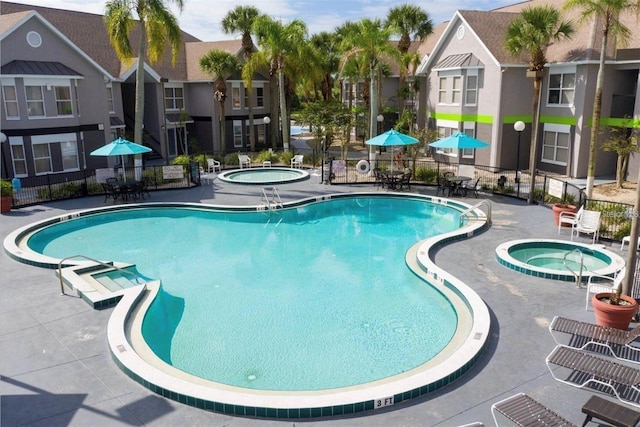 view of pool featuring a hot tub and a patio