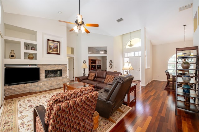 living room featuring dark wood-type flooring, built in features, ceiling fan, high vaulted ceiling, and a fireplace