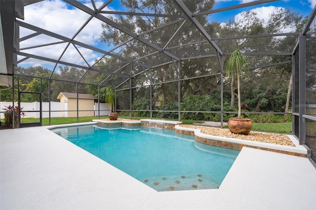 view of swimming pool with a shed, a patio area, and glass enclosure