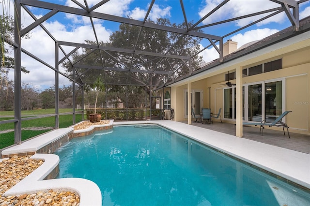 view of swimming pool featuring a patio area, ceiling fan, and glass enclosure