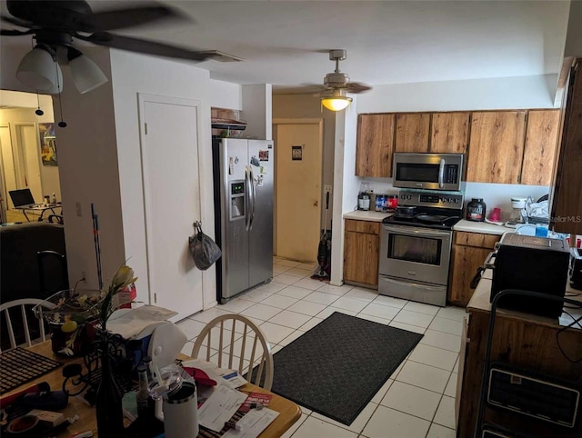 kitchen with light tile patterned floors, stainless steel appliances, and ceiling fan