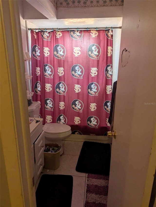 bathroom with tile patterned flooring, vanity, toilet, and walk in shower