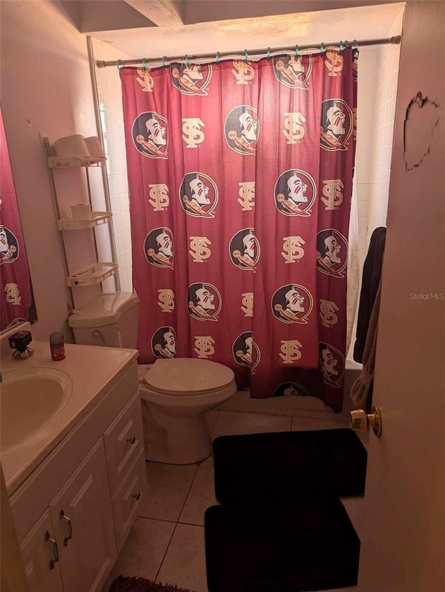 bathroom with tile patterned flooring, vanity, toilet, and walk in shower