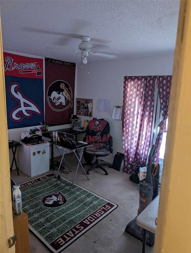 office area with ceiling fan, carpet floors, and a textured ceiling