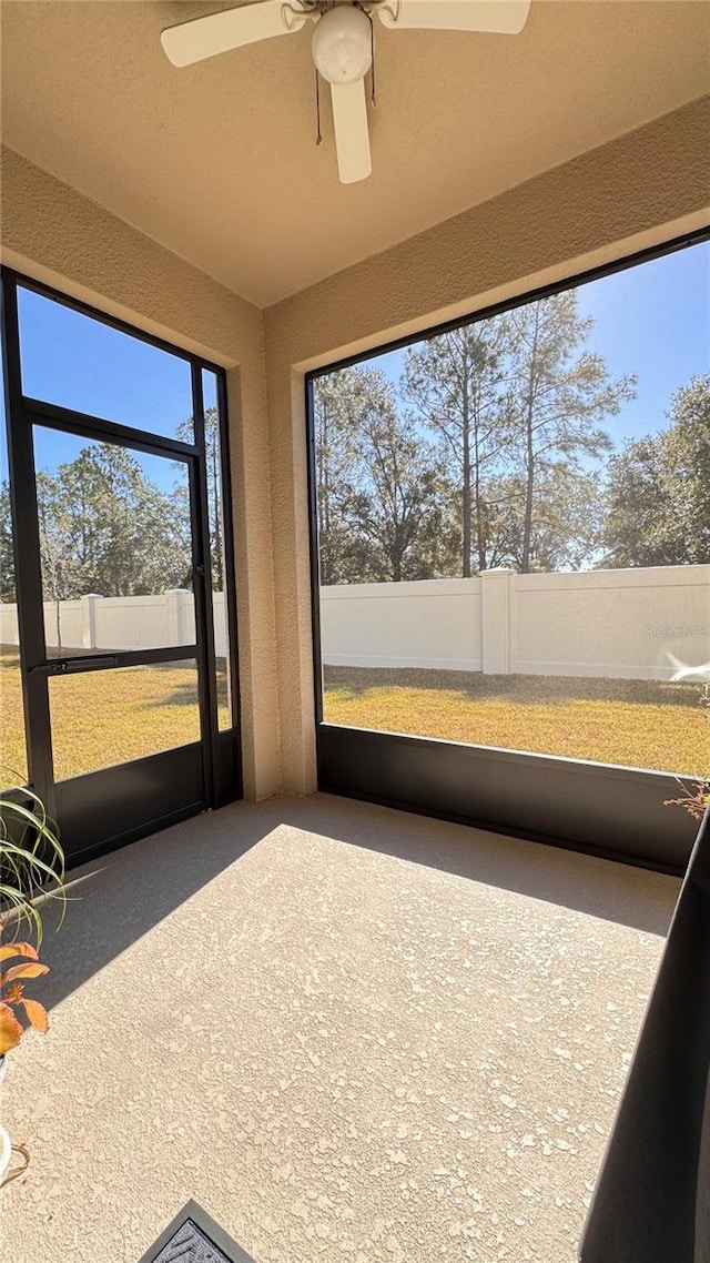 unfurnished sunroom with ceiling fan