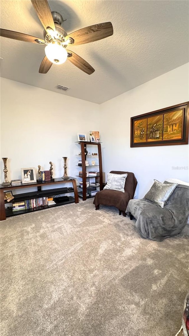 living area with carpet flooring and a textured ceiling