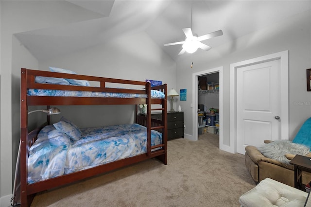 bedroom featuring light carpet, lofted ceiling, ceiling fan, a walk in closet, and a closet