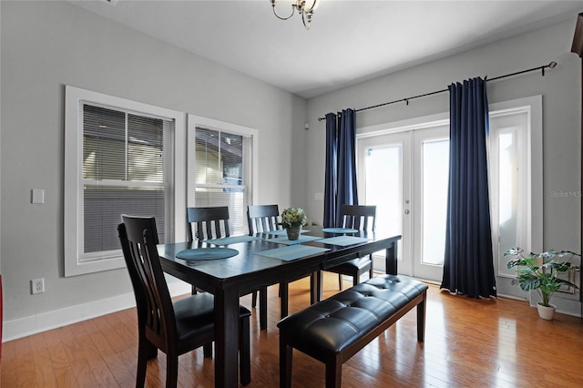 dining area with french doors, baseboards, and wood finished floors