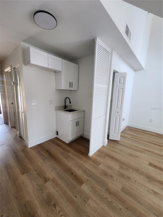 hall with wood-type flooring and sink