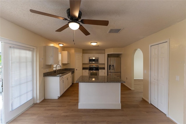 kitchen featuring white cabinetry, appliances with stainless steel finishes, sink, and light hardwood / wood-style flooring