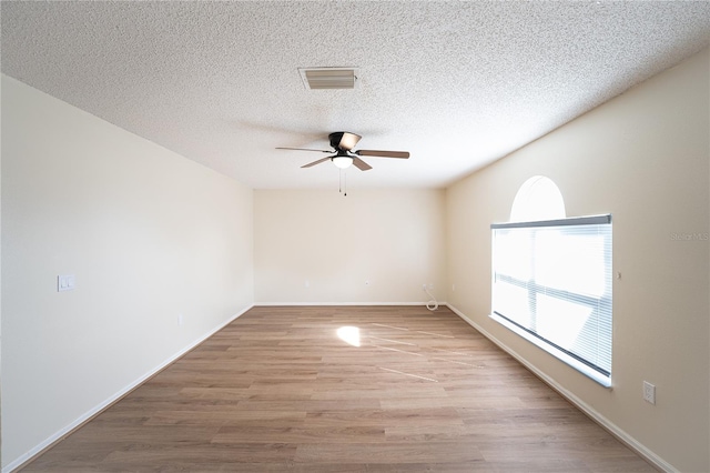 spare room featuring ceiling fan, a textured ceiling, and light wood-type flooring