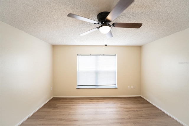 empty room featuring ceiling fan, light hardwood / wood-style floors, and a textured ceiling