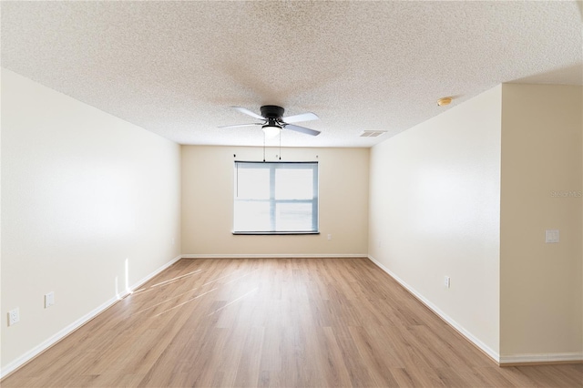 spare room with ceiling fan, light hardwood / wood-style floors, and a textured ceiling