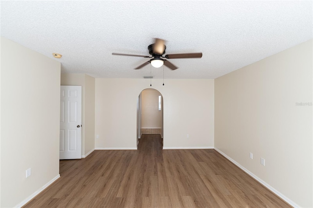 spare room featuring hardwood / wood-style flooring, ceiling fan, and a textured ceiling