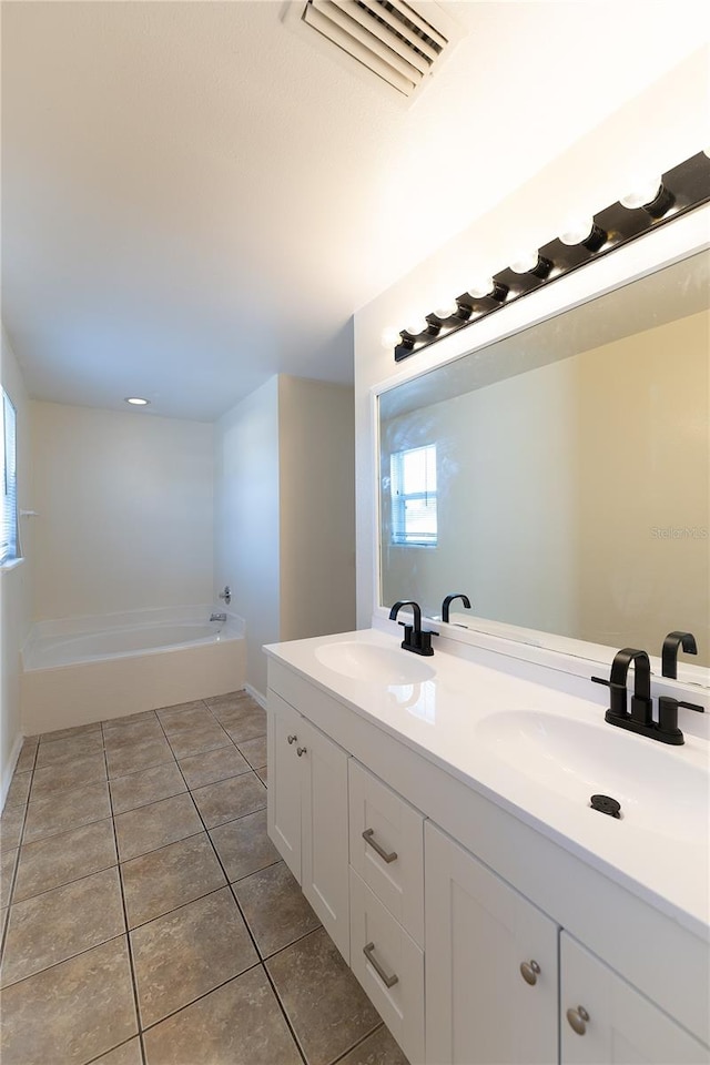 bathroom featuring tile patterned flooring, a tub to relax in, and vanity