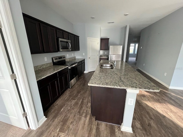 kitchen featuring a kitchen island with sink, sink, dark hardwood / wood-style flooring, and stainless steel appliances