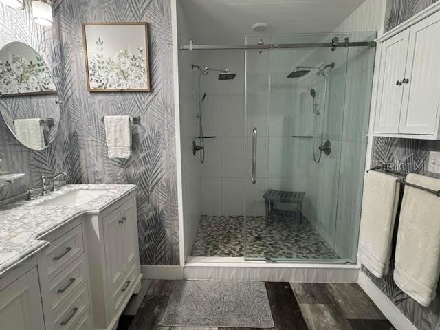 bathroom featuring vanity, wood-type flooring, and a shower with shower door