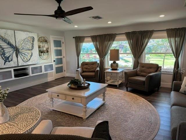 living room with plenty of natural light, dark hardwood / wood-style floors, and ceiling fan