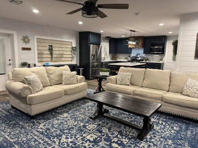 living room with ceiling fan, dark hardwood / wood-style flooring, and sink