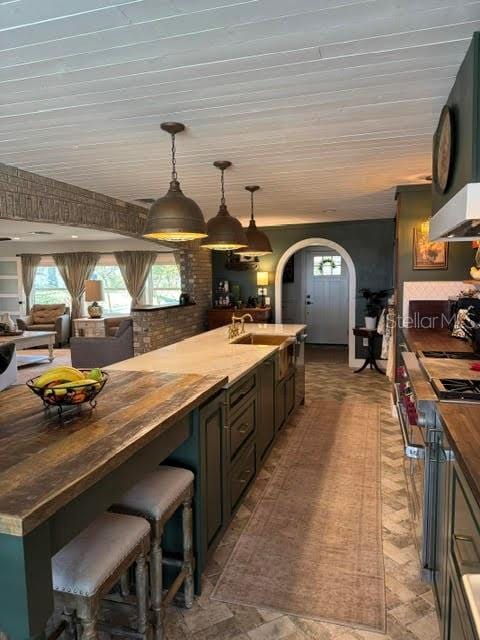 kitchen with sink, decorative light fixtures, and wooden counters