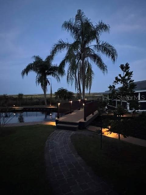 yard at dusk featuring a water view