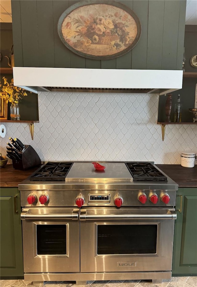 kitchen featuring butcher block counters, backsplash, green cabinets, and range with two ovens