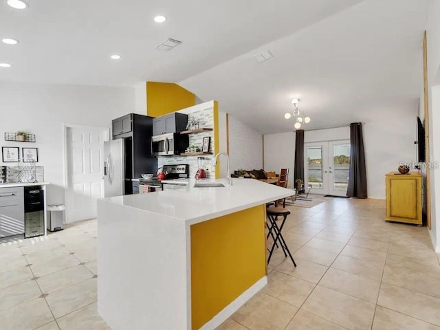 kitchen with lofted ceiling, sink, a breakfast bar area, stainless steel appliances, and wine cooler