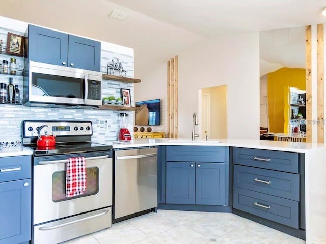 kitchen featuring lofted ceiling, sink, backsplash, kitchen peninsula, and stainless steel appliances