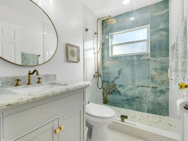 bathroom with vanity, tiled shower, and toilet