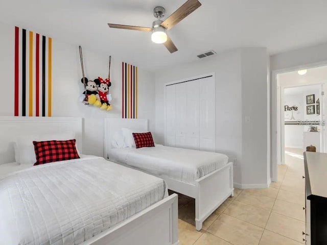 bedroom featuring light tile patterned floors, a closet, and ceiling fan