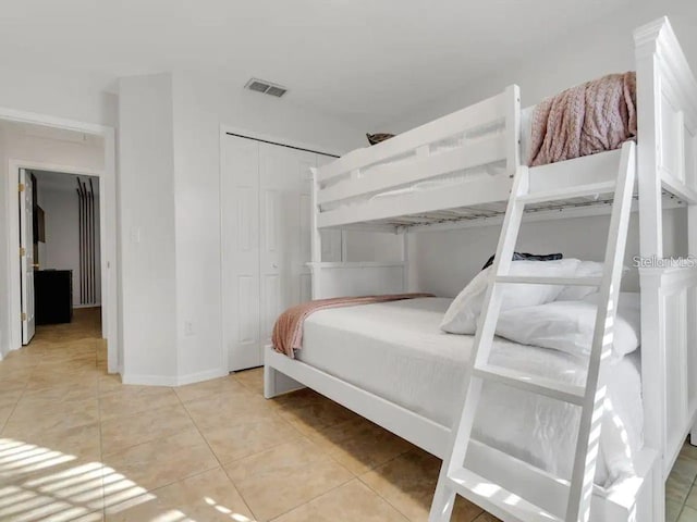 tiled bedroom featuring a closet