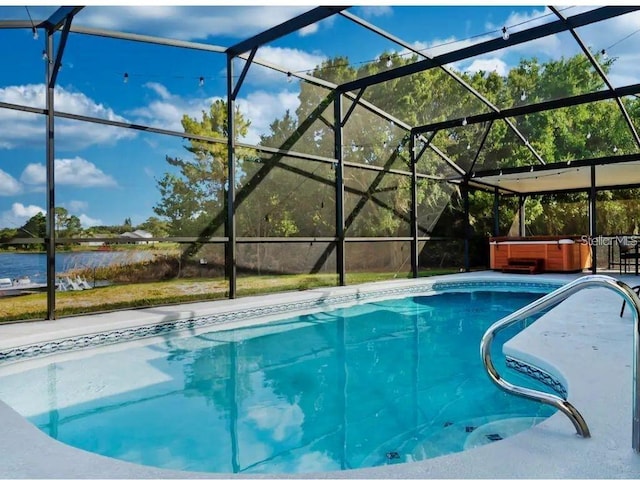 view of swimming pool with a lanai, a hot tub, a patio, and a water view