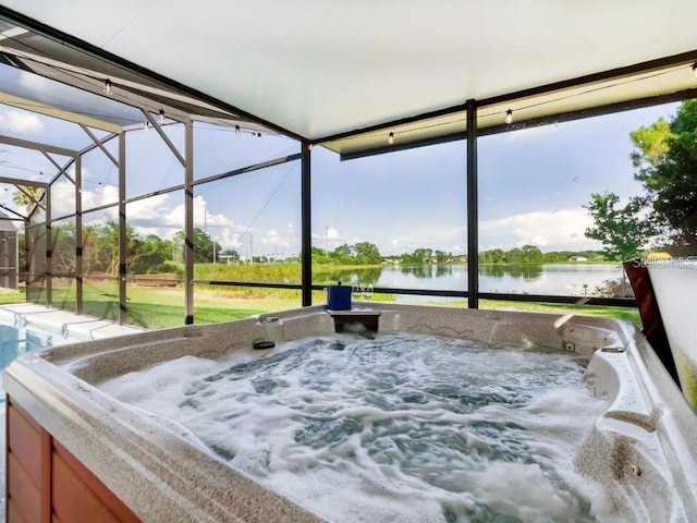 sunroom with a water view and a hot tub